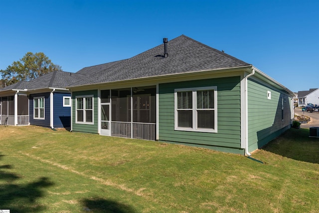 rear view of property featuring a lawn and a sunroom