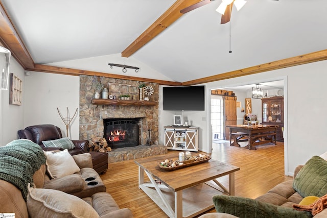 living room with vaulted ceiling with beams, light hardwood / wood-style floors, a fireplace, and ceiling fan with notable chandelier