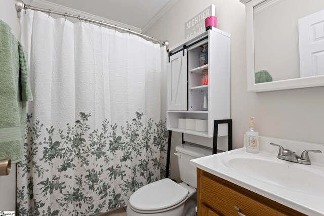 bathroom with vanity, toilet, and crown molding