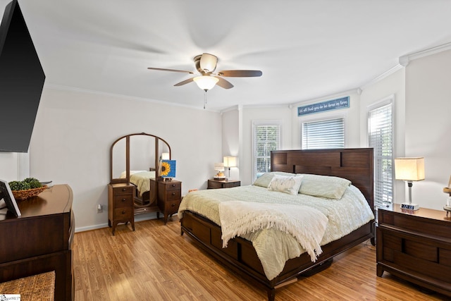 bedroom with multiple windows, light hardwood / wood-style floors, ceiling fan, and ornamental molding