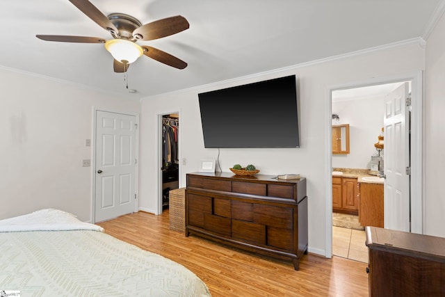 bedroom with ceiling fan, light wood-type flooring, crown molding, and connected bathroom