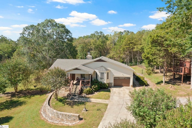 view of front of property featuring covered porch, a garage, and a front lawn