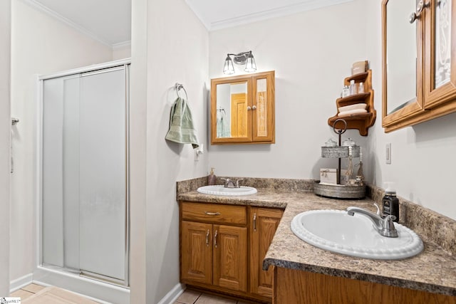 bathroom with tile patterned flooring, a shower with shower door, ornamental molding, and vanity