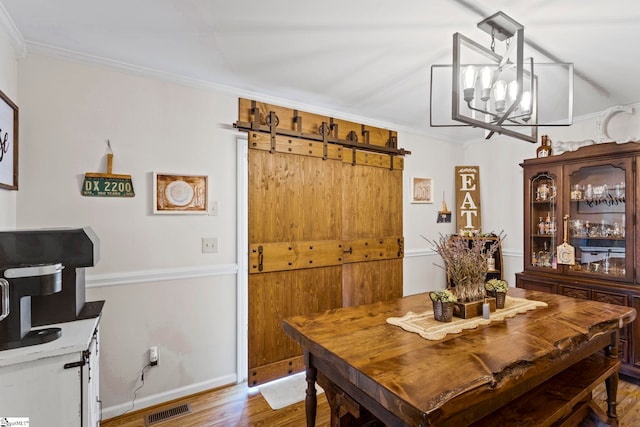 dining space featuring hardwood / wood-style floors, a chandelier, and ornamental molding