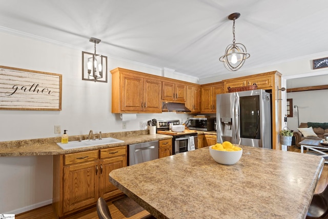 kitchen with a breakfast bar, appliances with stainless steel finishes, decorative light fixtures, and sink