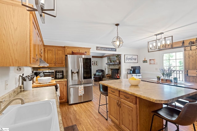 kitchen featuring appliances with stainless steel finishes, light hardwood / wood-style floors, ornamental molding, and sink