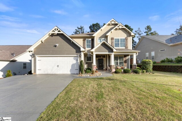 craftsman-style house featuring a porch, a front yard, and a garage