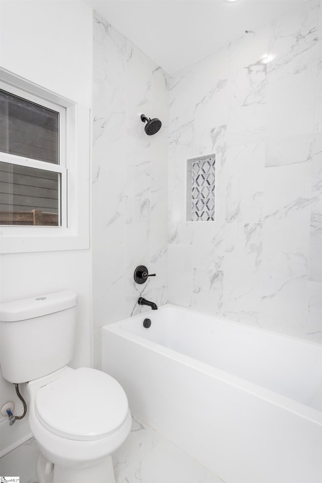 bathroom with toilet and tiled shower / bath