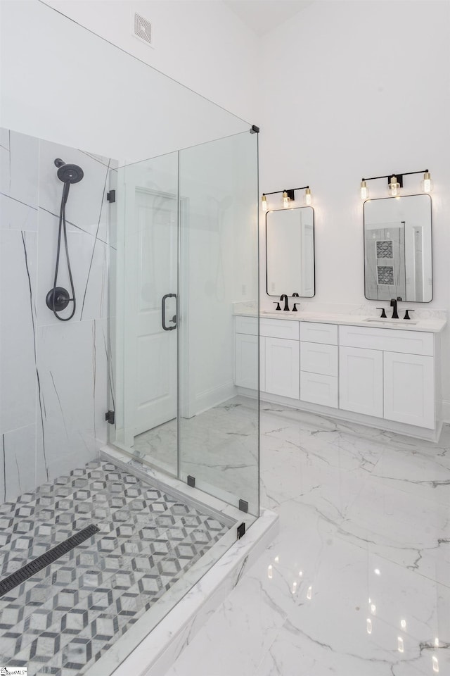 bathroom featuring a shower with door and vanity