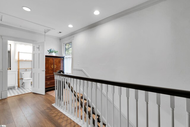 corridor featuring ornamental molding and hardwood / wood-style floors