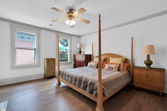 bedroom with ceiling fan, multiple windows, dark hardwood / wood-style floors, and crown molding