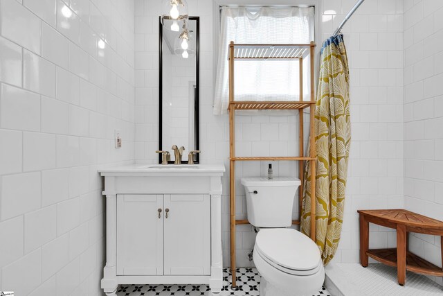 bathroom featuring tile walls, toilet, walk in shower, and vanity