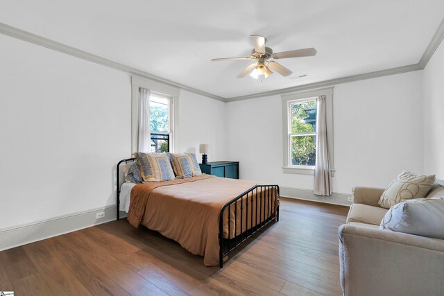 bedroom with ceiling fan, crown molding, and dark wood-type flooring