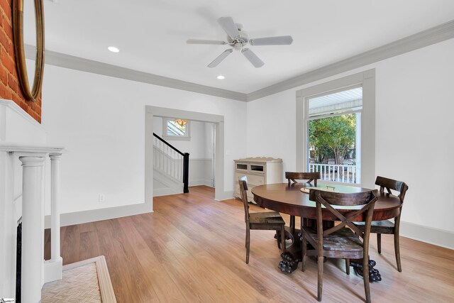 dining space with ceiling fan, light hardwood / wood-style flooring, ornamental molding, and a fireplace