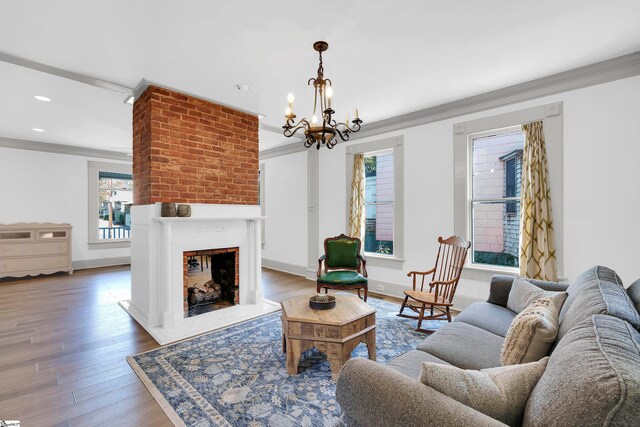 living room featuring hardwood / wood-style flooring, an inviting chandelier, and ornamental molding