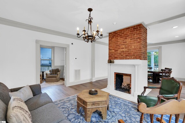 living room featuring hardwood / wood-style floors, crown molding, and an inviting chandelier