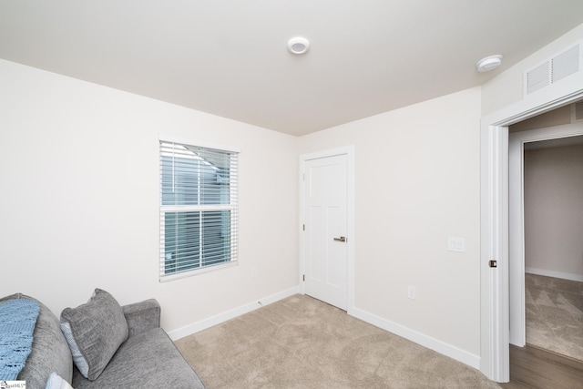 sitting room featuring light colored carpet