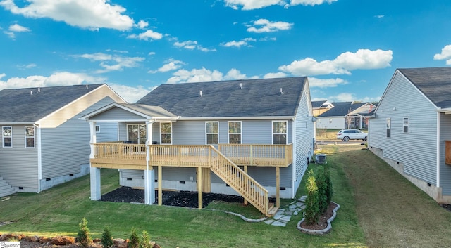 rear view of house featuring a lawn and a deck