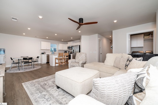 living room with dark hardwood / wood-style floors and ceiling fan