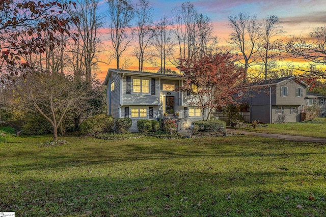 split foyer home featuring a yard