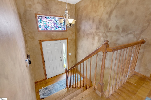 entrance foyer with hardwood / wood-style flooring and an inviting chandelier