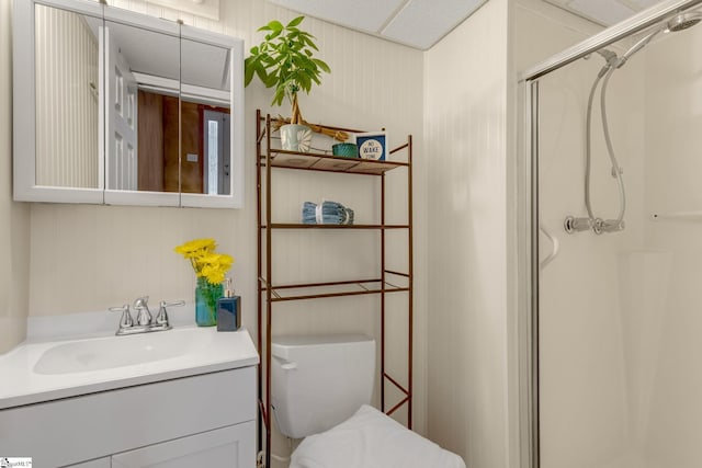 bathroom with vanity, toilet, and a shower with door