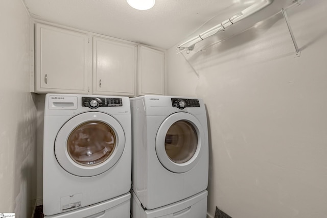 laundry room with separate washer and dryer, cabinets, and a textured ceiling