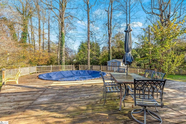 view of pool with a shed and a deck