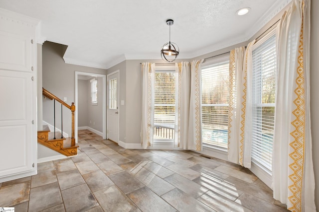 entryway featuring crown molding, plenty of natural light, and a textured ceiling