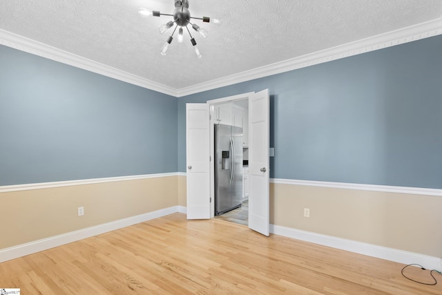 unfurnished room featuring crown molding, a textured ceiling, and light hardwood / wood-style flooring