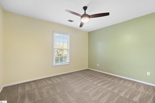 carpeted spare room featuring ceiling fan