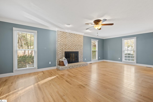 unfurnished living room featuring a fireplace, light hardwood / wood-style flooring, plenty of natural light, and crown molding