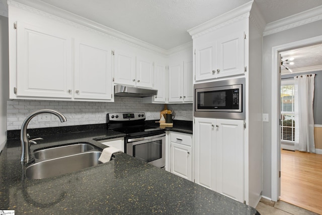 kitchen featuring backsplash, ornamental molding, stainless steel appliances, sink, and white cabinets