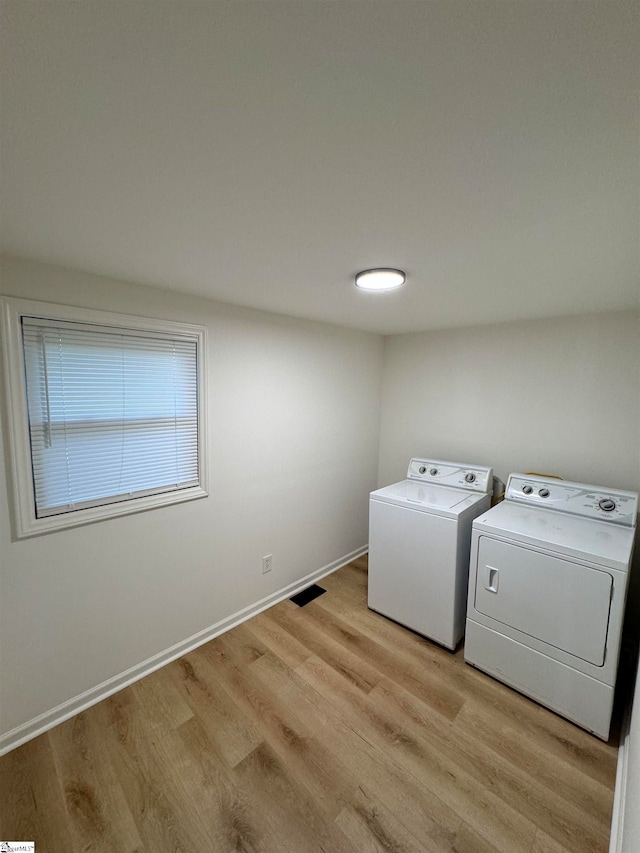 washroom featuring separate washer and dryer and light hardwood / wood-style flooring