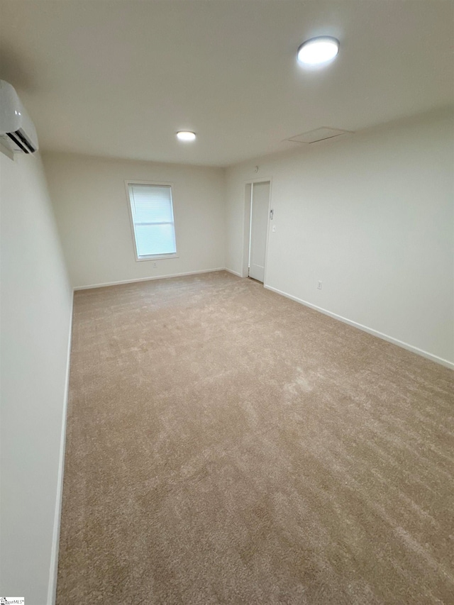 carpeted spare room featuring a wall unit AC