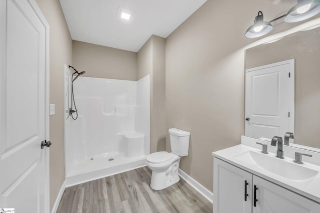 bathroom featuring hardwood / wood-style floors, toilet, a shower, and vanity