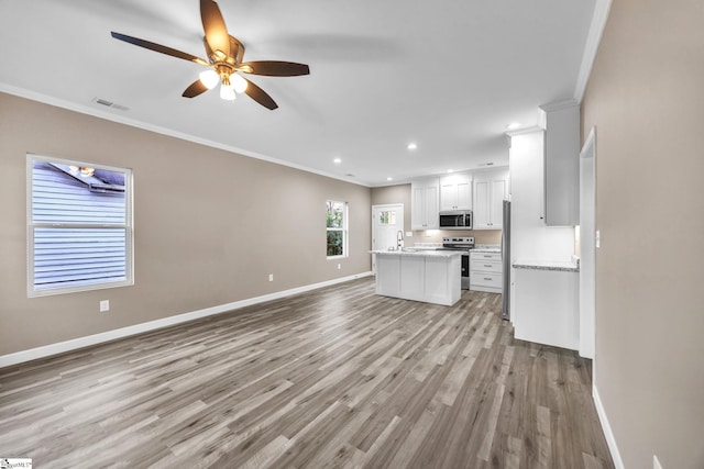 unfurnished living room with light wood-type flooring, ceiling fan, crown molding, and sink