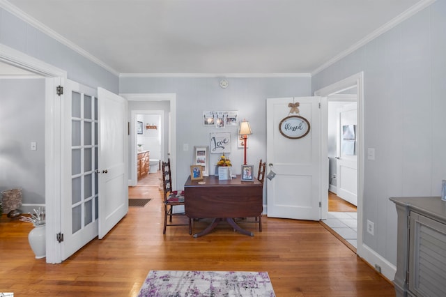 dining room with light wood-type flooring and ornamental molding