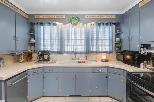 kitchen with tile counters, a healthy amount of sunlight, and sink