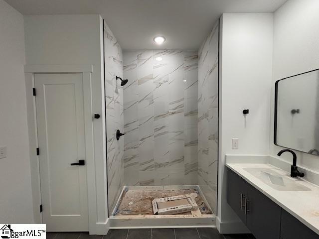 full bath featuring recessed lighting, vanity, and a marble finish shower