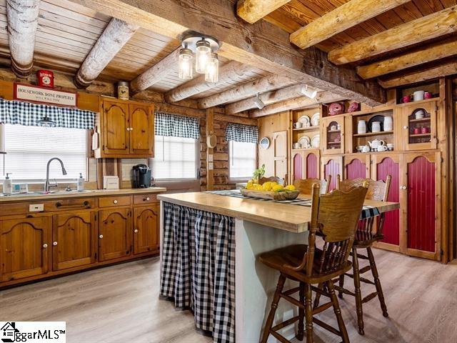 kitchen featuring beamed ceiling, wooden ceiling, sink, and light hardwood / wood-style flooring