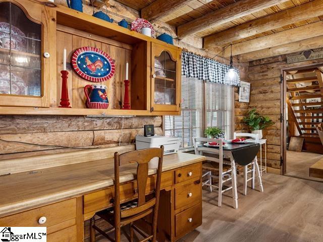 bar featuring beam ceiling, light wood-type flooring, hanging light fixtures, and wooden ceiling