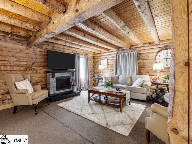 living room featuring log walls, beam ceiling, a fireplace, and wood ceiling