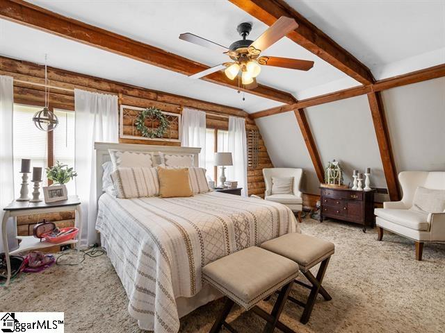 carpeted bedroom featuring vaulted ceiling with beams, ceiling fan, and multiple windows