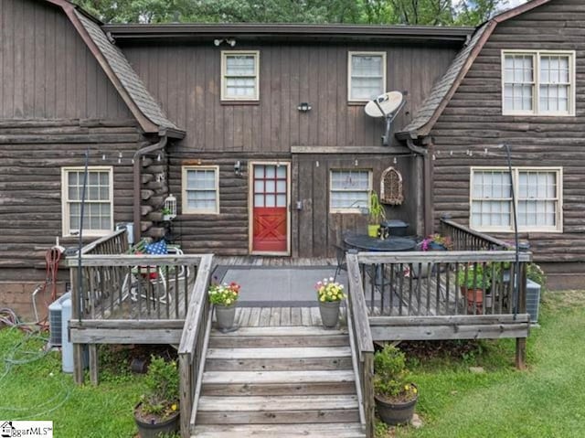 view of front of property with central AC unit, a deck, and a front yard