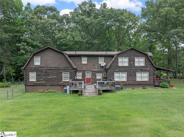 rear view of property with a lawn and cooling unit