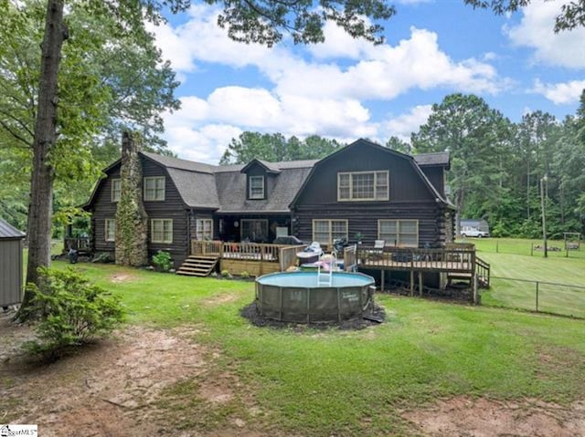 back of property featuring a lawn and a pool side deck