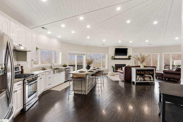 kitchen with white cabinets, a healthy amount of sunlight, a breakfast bar area, and appliances with stainless steel finishes