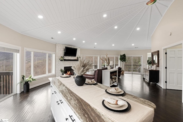 dining area featuring wooden ceiling, a fireplace, dark wood-type flooring, and vaulted ceiling