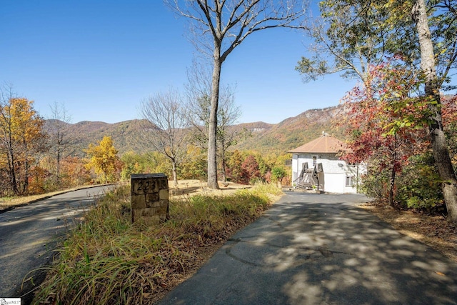 view of road with aphalt driveway and a mountain view